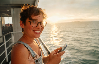 Woman holding a smartphone on board the ship